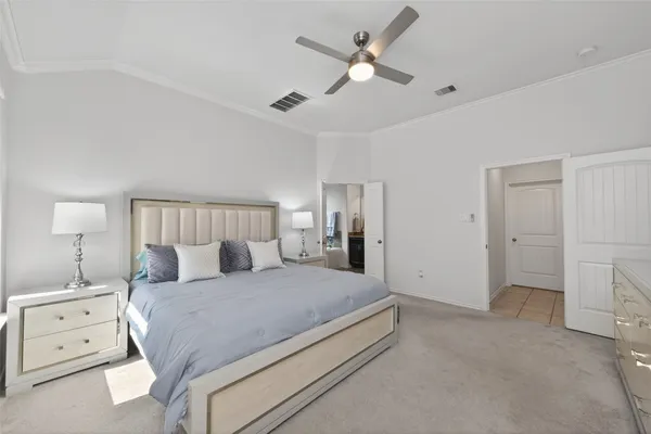 a spacious bedroom with a bed and a chandelier