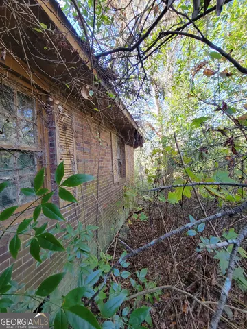 a backyard of a house with lots of plants and trees