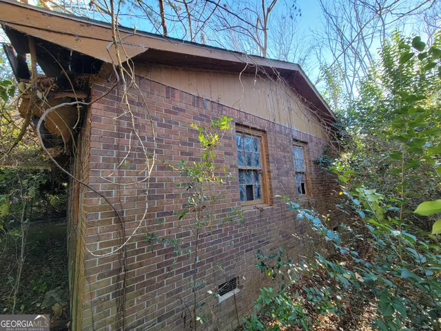 a view of a wooden house with a small yard