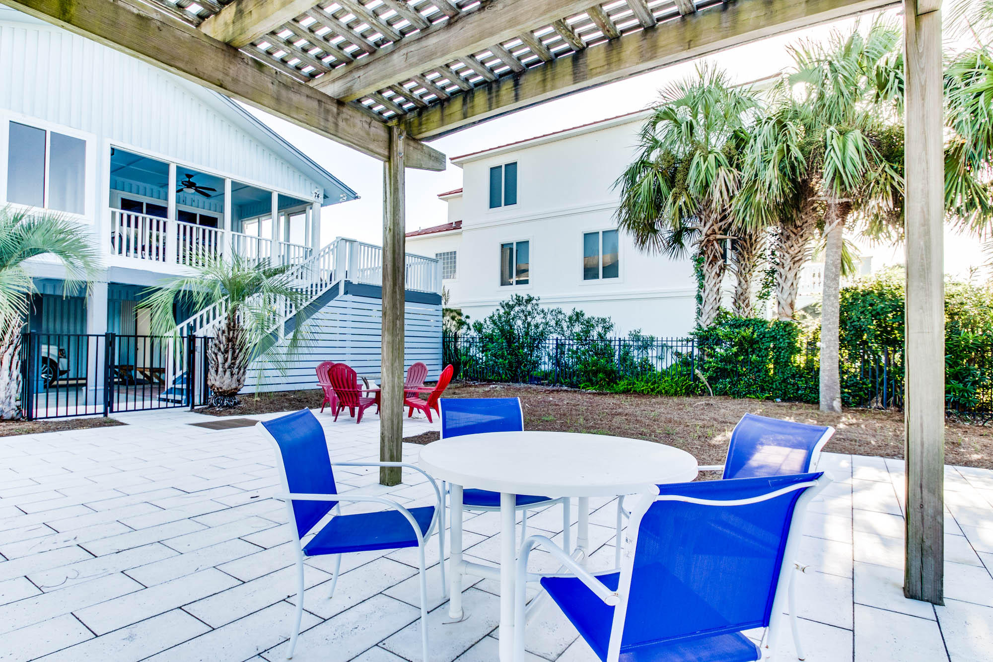74 Pompano Street Inlet Beach, FL 32461 - Photo 34 of 46 a view of a patio with table and chairs potted plants with wooden floor and fence