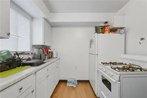 a kitchen with sink a stove and white cabinets