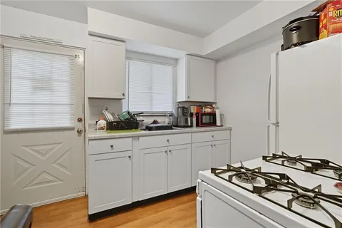 a kitchen with stainless steel appliances a stove and white cabinets