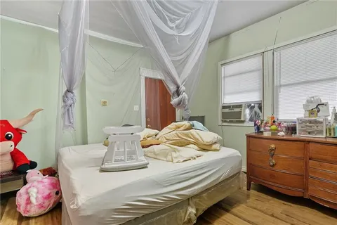 a bedroom with a bed and large windows