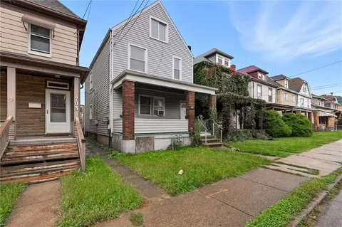 a view of a house with a yard porch and a street