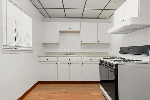 a kitchen with granite countertop white cabinets and white appliances