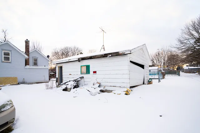 a view of a white house with a snow on the road