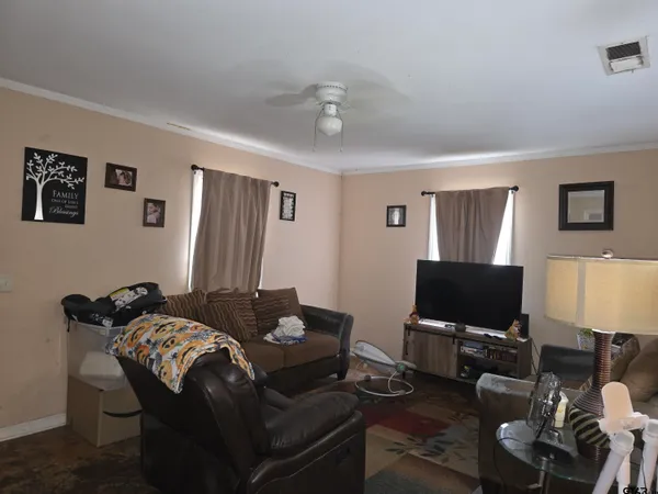a living room with furniture a flat screen tv and a window