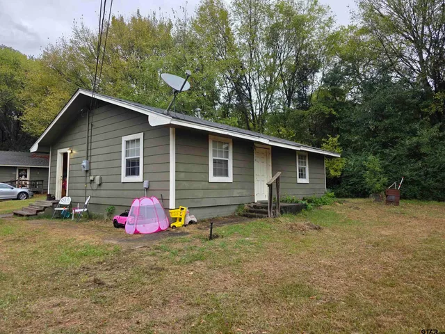 a backyard of a house with table and chairs