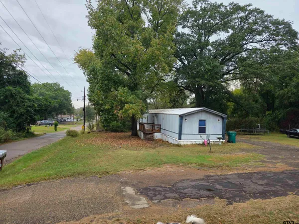 a view of a house with a big yard and large trees