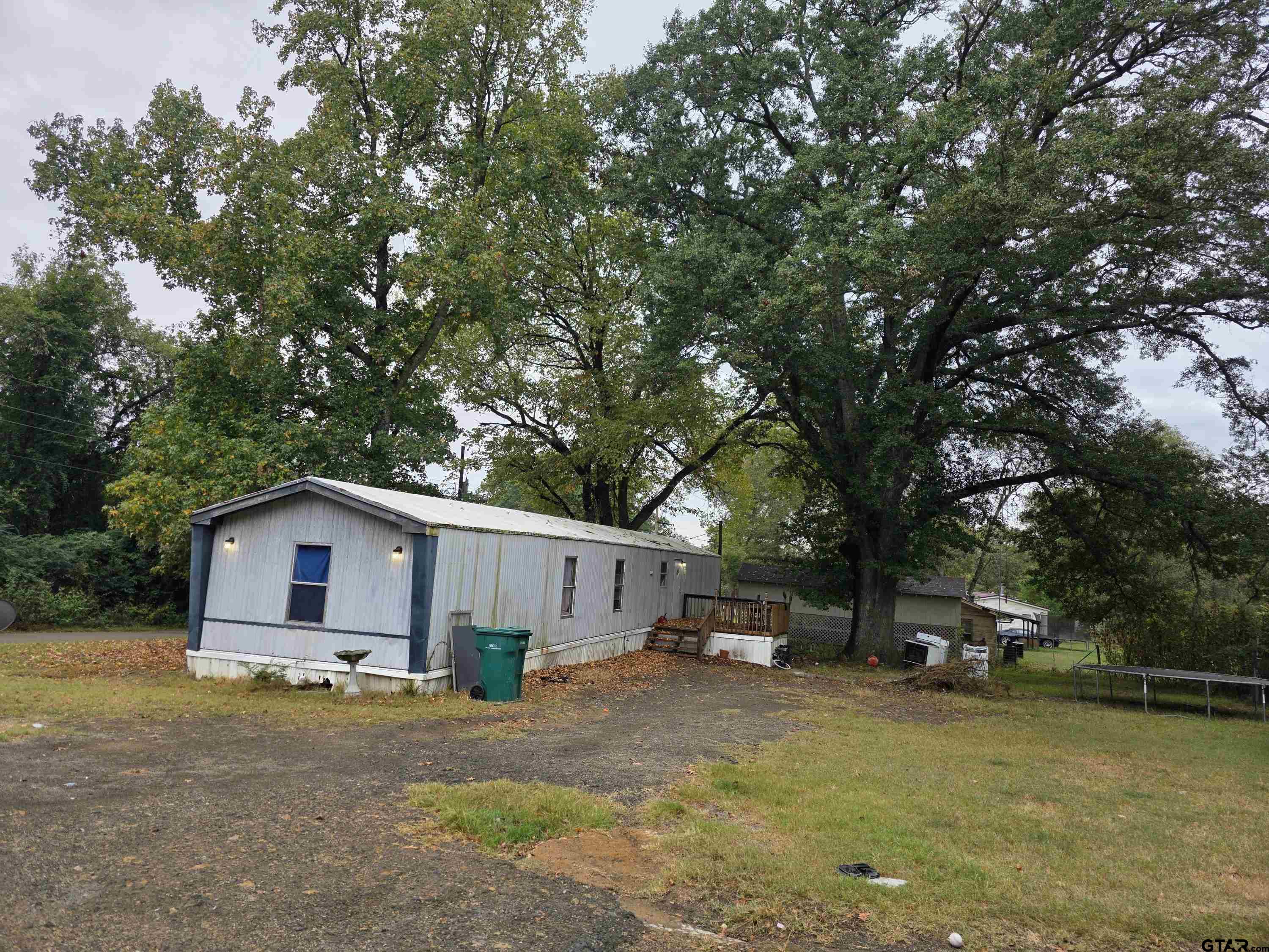 304 Walnut Street Naples, TX 75568 - Photo 5 of 28 a yellow and red house with a tree in front of it