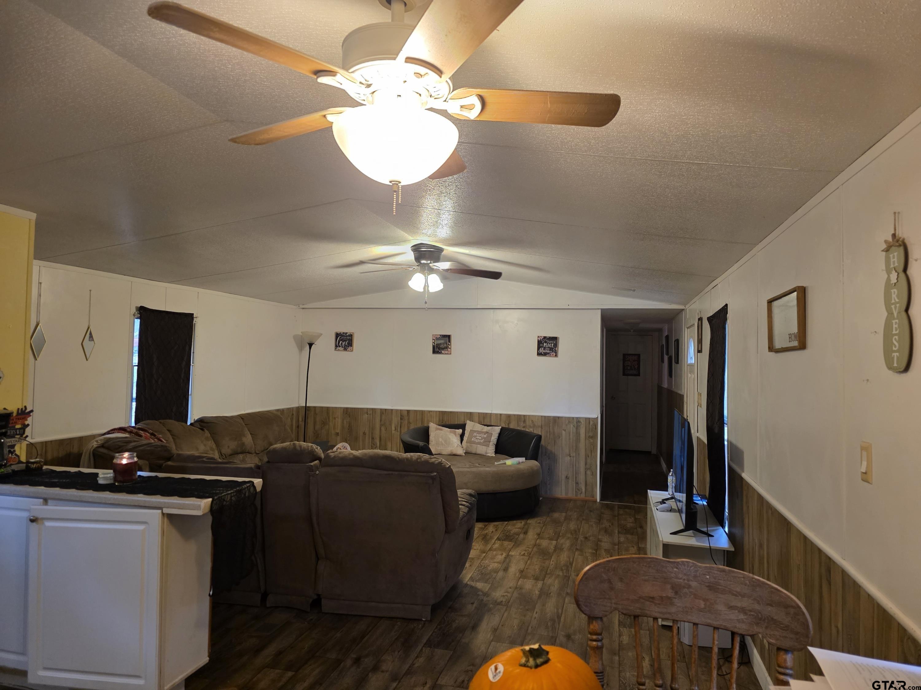 304 Walnut Street Naples, TX 75568 - Photo 7 of 28 a living room with large couches chandelier and a dining table with chandelier