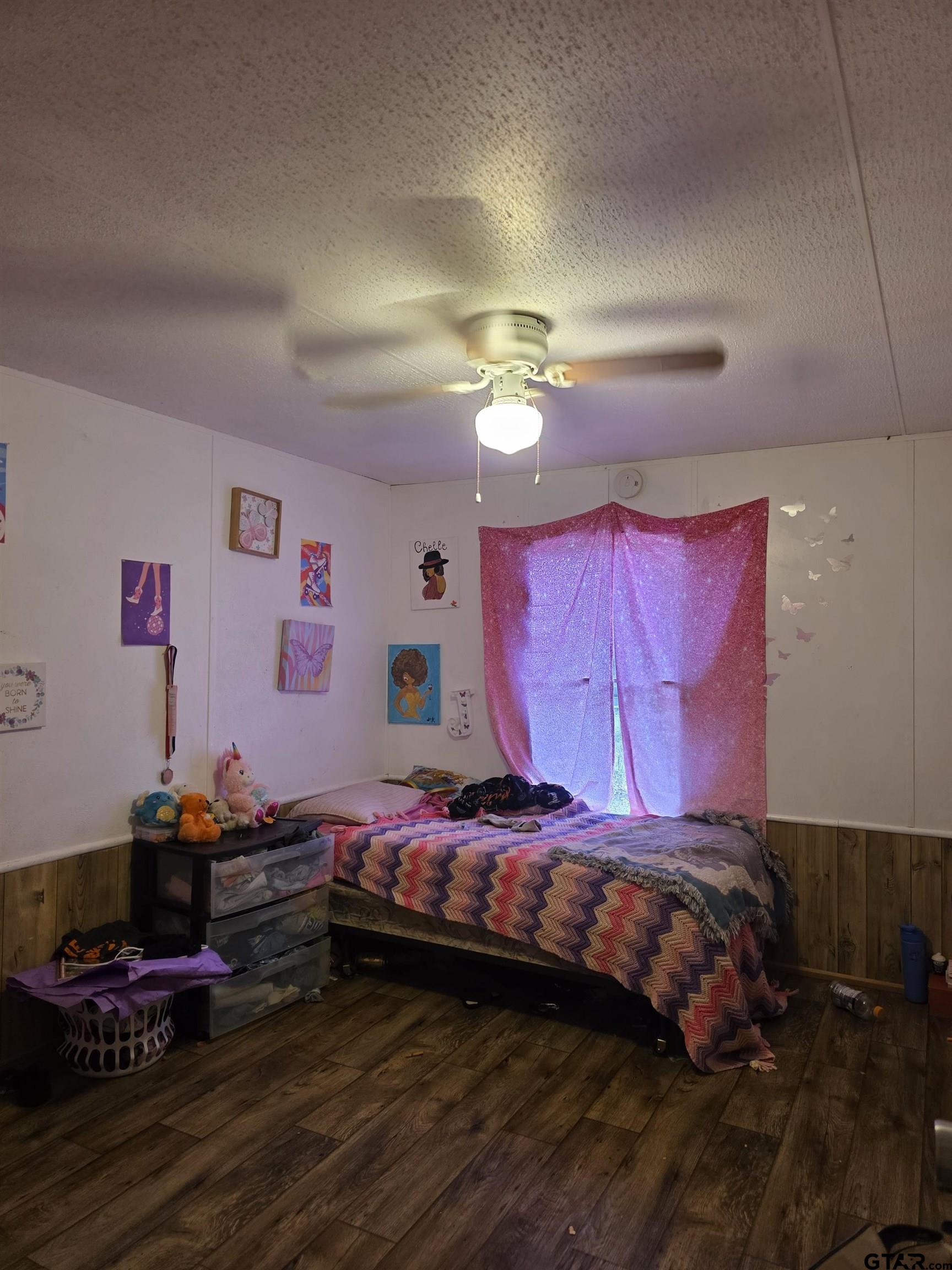 304 Walnut Street Naples, TX 75568 - Photo 10 of 28 a bedroom with a bed and a chandelier