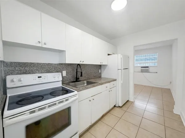 a kitchen with a stove top oven and cabinets