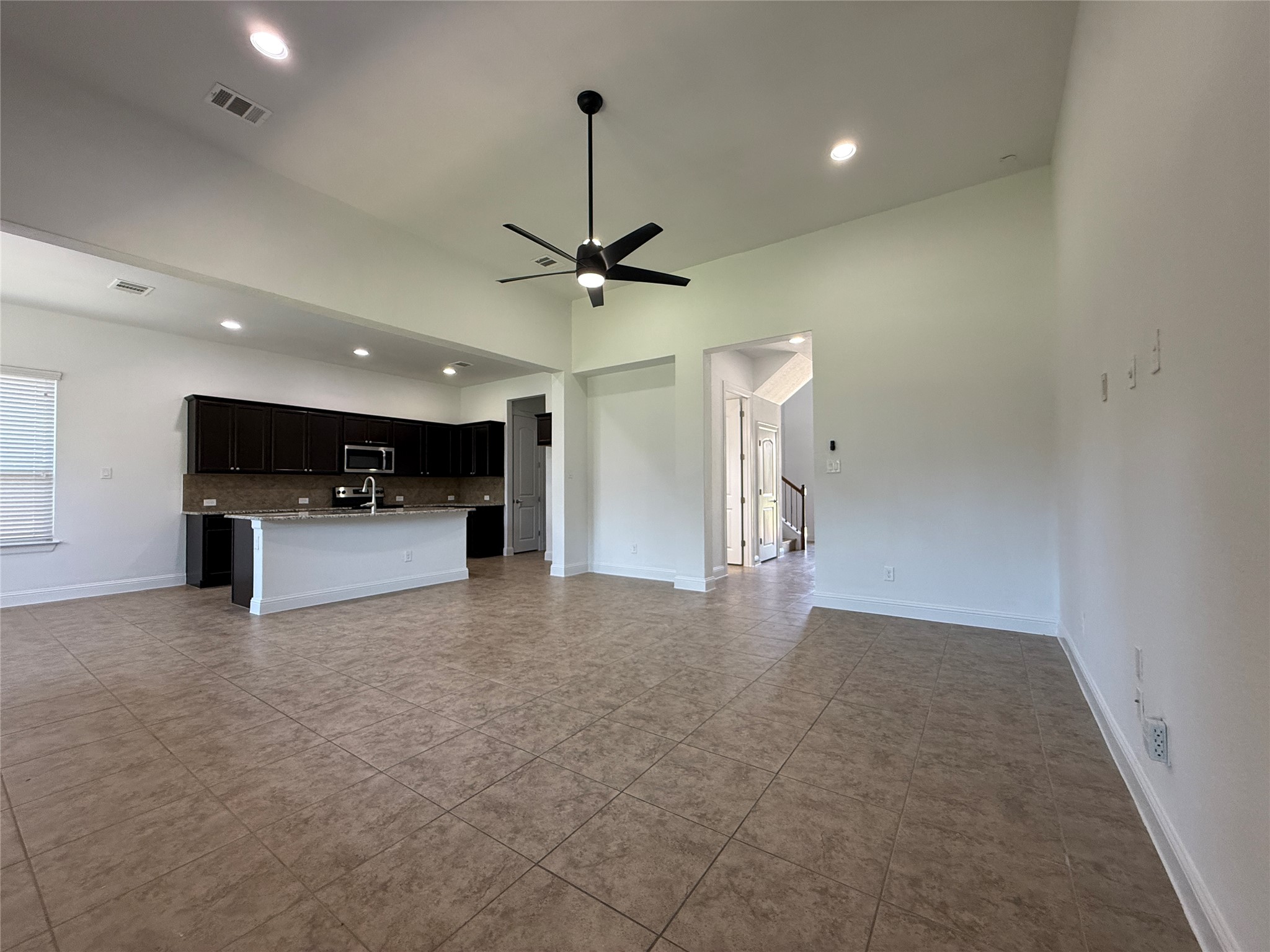 1512 Long Shadow Lane Georgetown, TX 78628 - Photo 7 of 19 a view of empty room with a ceiling fan and kitchen view