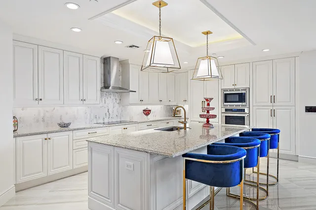 a kitchen with white cabinets and sink