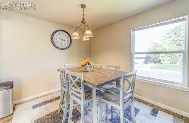 a view of a dining room with furniture a chandelier and a window