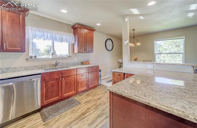 a kitchen with stainless steel appliances granite countertop a sink a stove counter space and cabinets