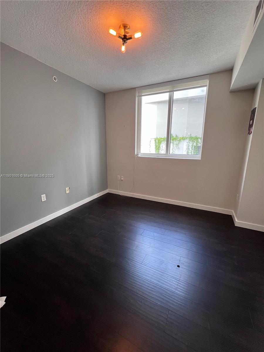 601 Northeast 23rd Street, Unit 606 Miami, FL 33137 - Photo 4 of 26 an empty room with wooden floor and windows