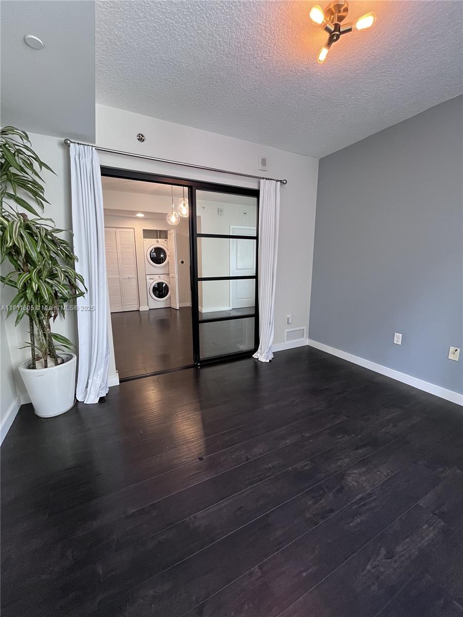 601 Northeast 23rd Street, Unit 606 Miami, FL 33137 - Photo 5 of 26 a view of an empty room with wooden floor and a potted plant