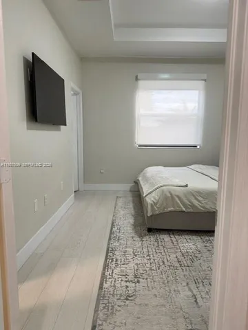 a bedroom with a bed and a flat screen tv