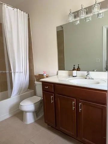 a bathroom with a granite countertop sink toilet and a mirror