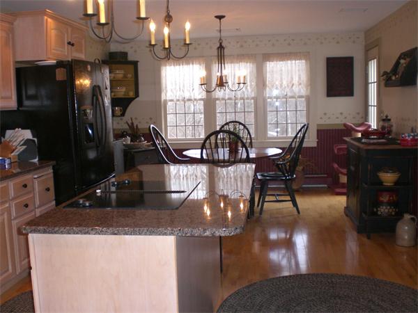 948 Cronin Road Warren, MA 01585 - Photo 15 of 25 a view of a dining room with furniture a chandelier and wooden floor