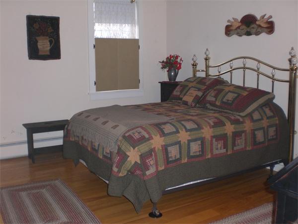 948 Cronin Road Warren, MA 01585 - Photo 20 of 25 a bedroom with a bed wooden floor and window