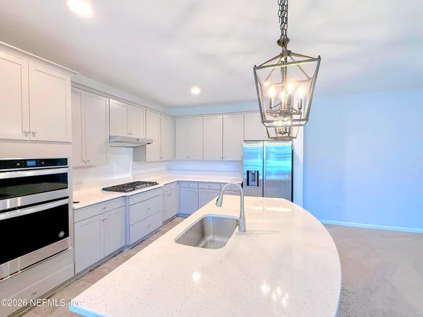 a large kitchen with kitchen island a stove a sink a refrigerator a center island a stove and a window