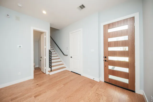 a view of an entryway with wooden floor and a bathroom view