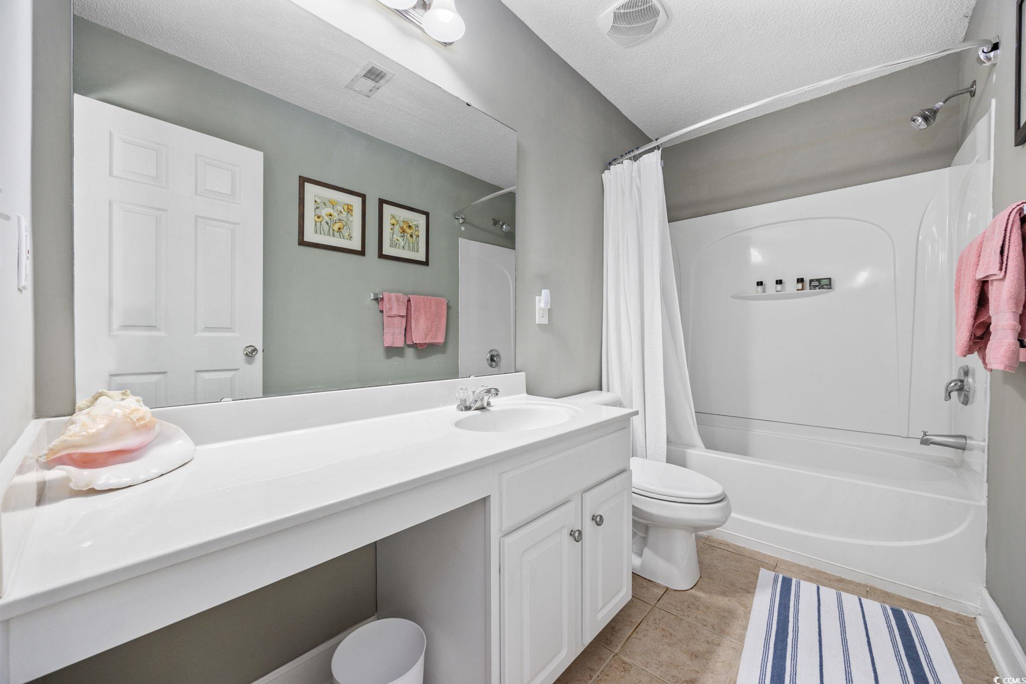 306 River Rock Lane, Unit 1304 Murrells Inlet, SC 29576 - Photo 26 of 40 Bathroom featuring shower / bathtub combination with curtain, light tile patterned floors, vanity, and a textured ceiling