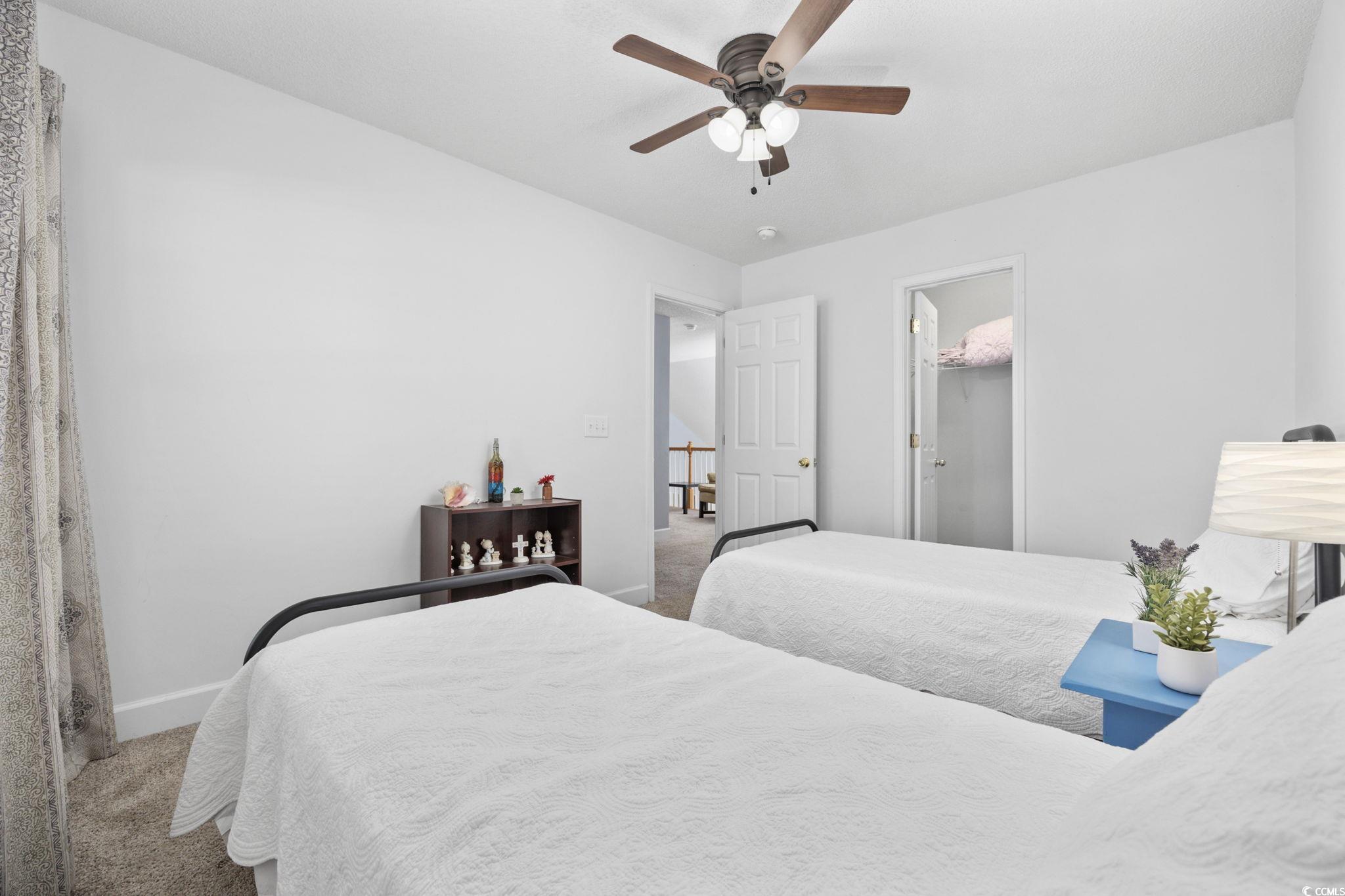 306 River Rock Lane, Unit 1304 Murrells Inlet, SC 29576 - Photo 28 of 40 Bedroom with light colored carpet, a ceiling fan, and a walk in closet