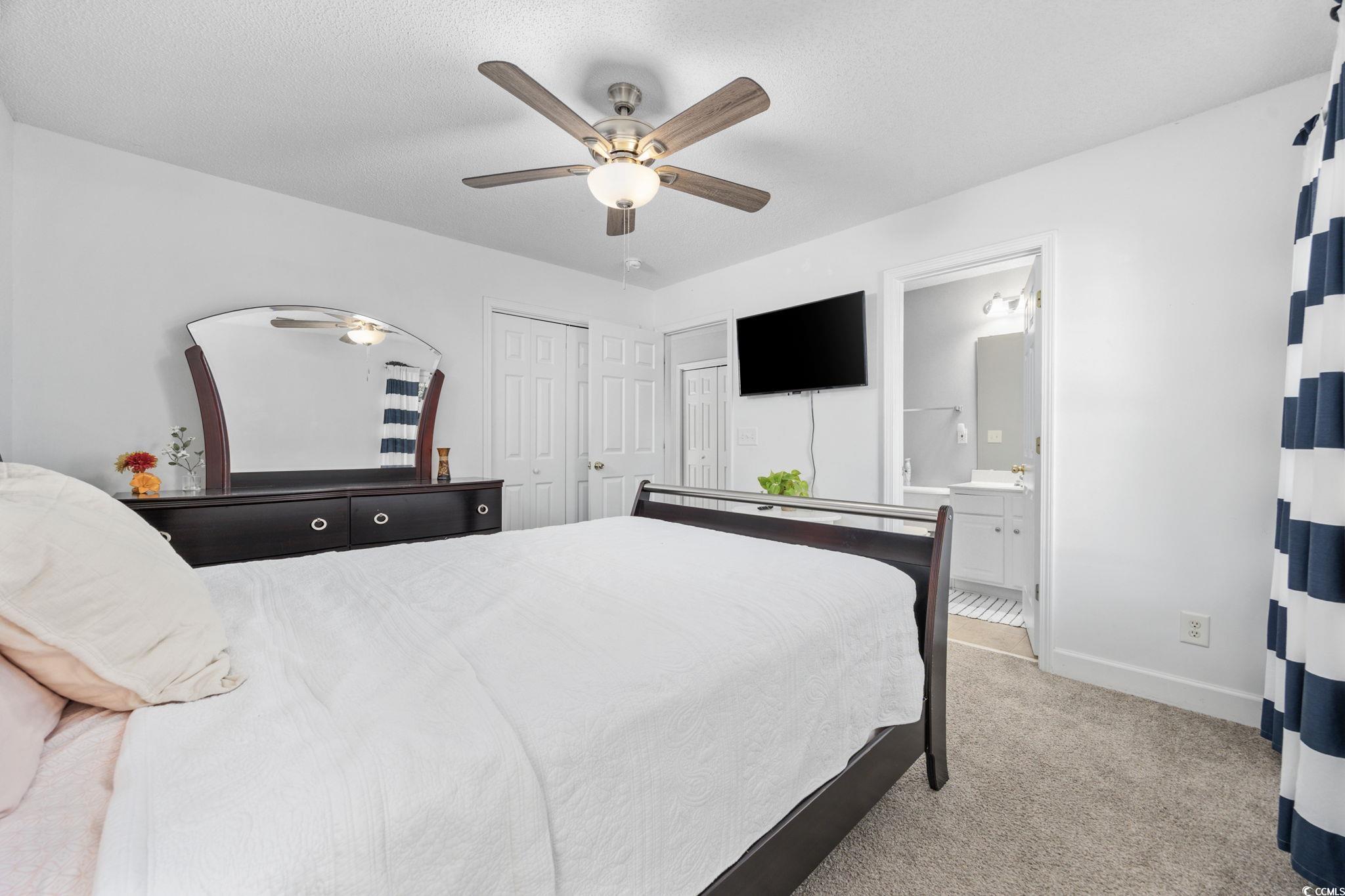 306 River Rock Lane, Unit 1304 Murrells Inlet, SC 29576 - Photo 31 of 40 Bedroom with light carpet, ceiling fan, a closet, and ensuite bath