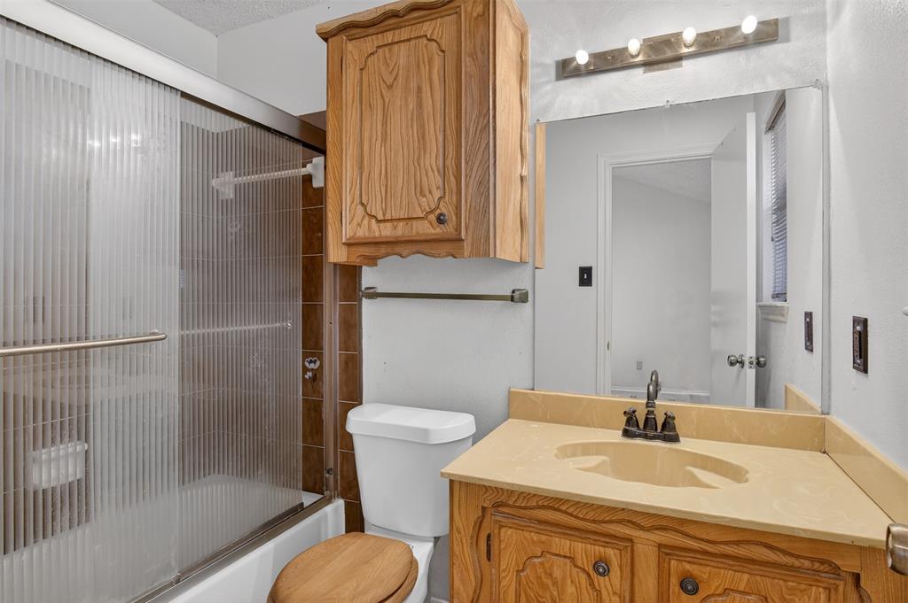6946 Trailcrest Drive Dallas, TX 75232 - Photo 13 of 22 a bathroom with a sink toilet and shower