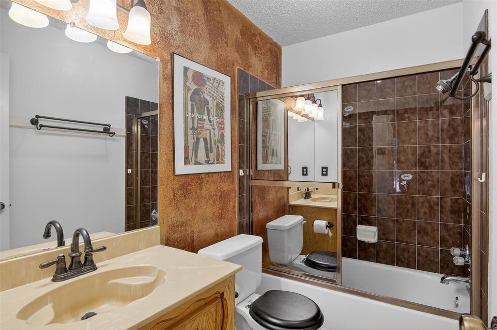 6946 Trailcrest Drive Dallas, TX 75232 - Photo 14 of 22 a bathroom with a sink a toilet and shower