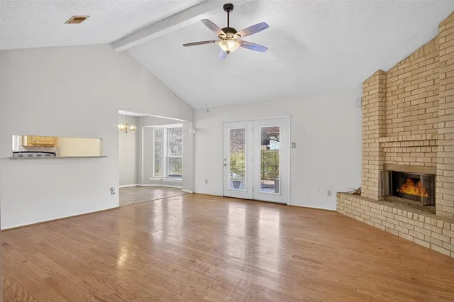 a view of an empty room with a fireplace and a window