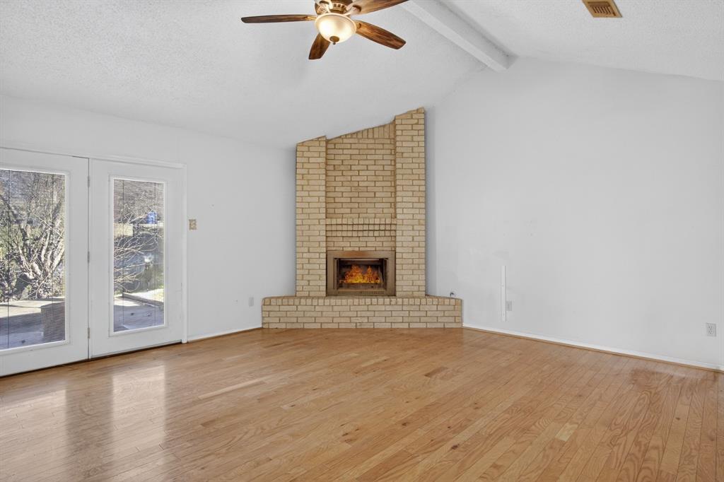 6946 Trailcrest Drive Dallas, TX 75232 - Photo 7 of 22 an empty room with windows and fireplace