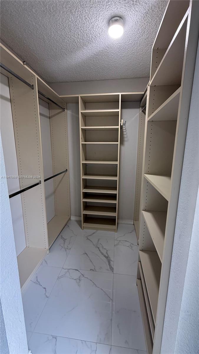 17600 Northwest 68th Avenue, Unit B2002 Hialeah, FL 33015 - Photo 11 of 38 a view of walk in closet with empty racks