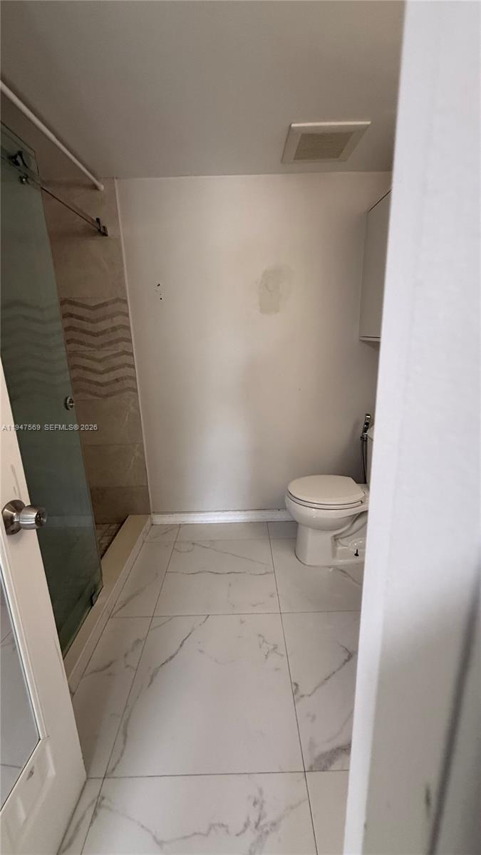 17600 Northwest 68th Avenue, Unit B2002 Hialeah, FL 33015 - Photo 13 of 38 a bathroom with a toilet and shower