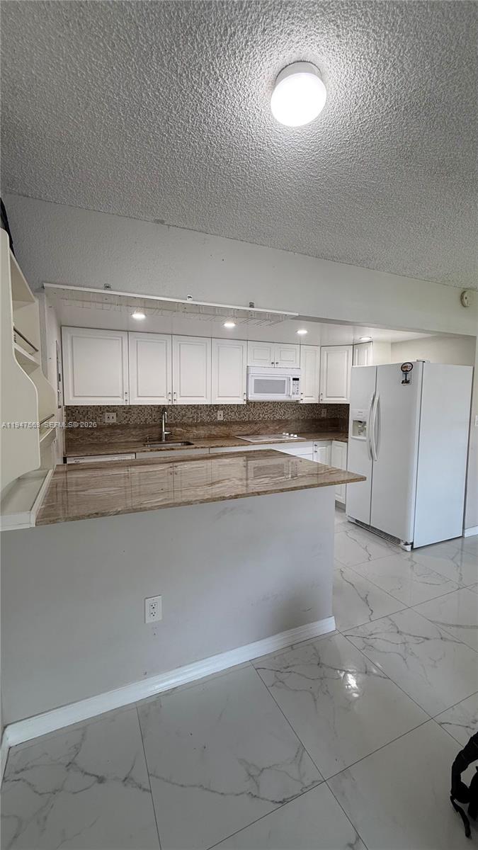 17600 Northwest 68th Avenue, Unit B2002 Hialeah, FL 33015 - Photo 15 of 38 a kitchen with stainless steel appliances granite countertop a refrigerator and a stove top oven