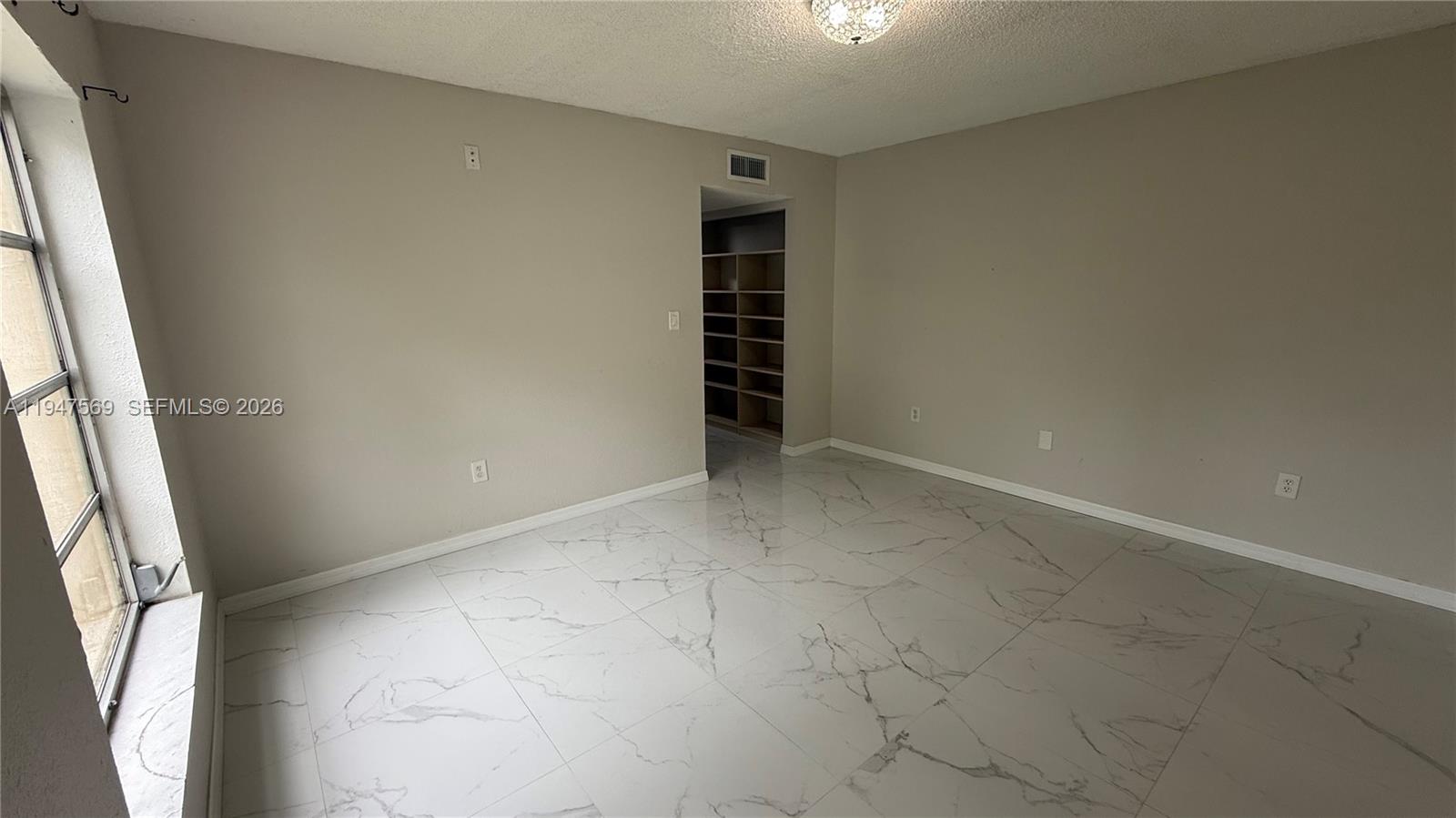 17600 Northwest 68th Avenue, Unit B2002 Hialeah, FL 33015 - Photo 31 of 38 an empty room with a fireplace and entryway