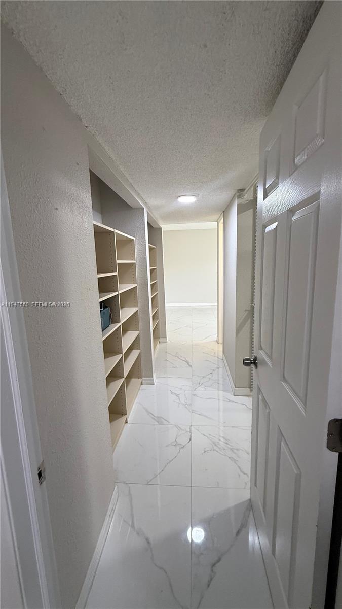 17600 Northwest 68th Avenue, Unit B2002 Hialeah, FL 33015 - Photo 33 of 38 a view of walk in closet with empty racks