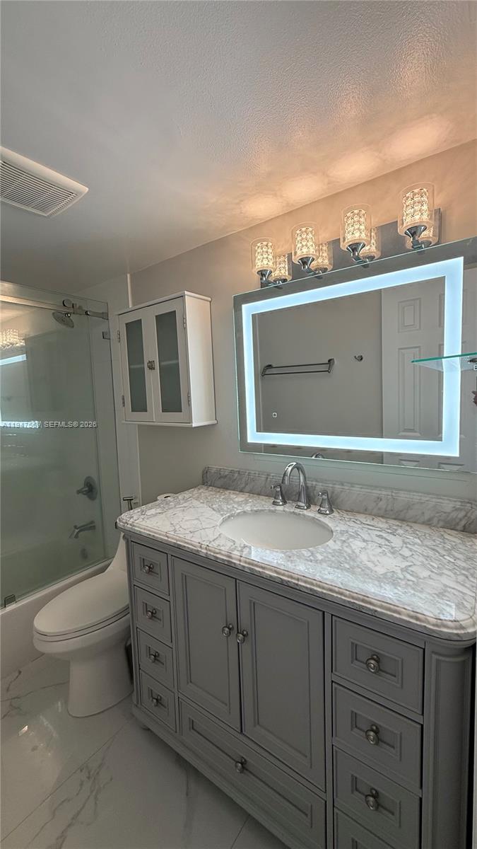 17600 Northwest 68th Avenue, Unit B2002 Hialeah, FL 33015 - Photo 35 of 38 a bathroom with a granite countertop sink toilet and mirror