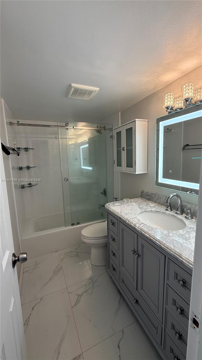 17600 Northwest 68th Avenue, Unit B2002 Hialeah, FL 33015 - Photo 36 of 38 a bathroom with a granite countertop sink a mirror and a