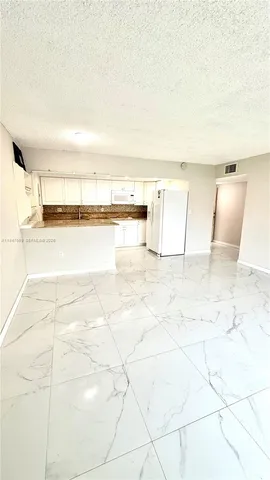 a kitchen with a refrigerator a stove top oven and a refrigerator