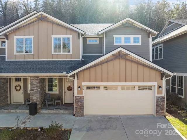 a view of a house with a garage and yard