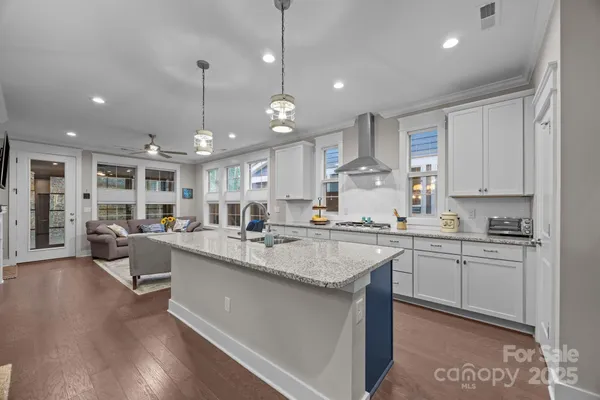 a large kitchen with kitchen island a sink a center island a stove a dining table and chairs