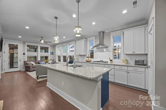 a large kitchen with kitchen island a sink a center island a stove a dining table and chairs