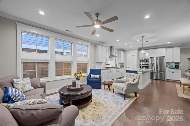 a living room with furniture kitchen and a large window