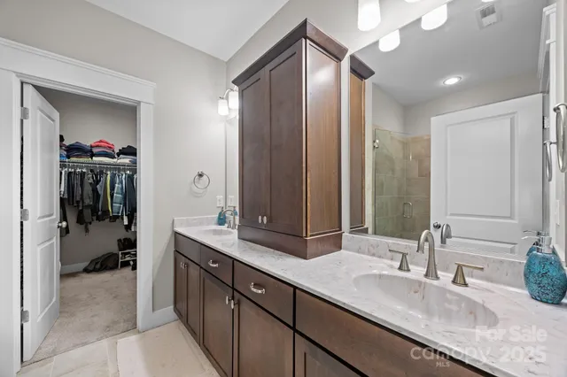 a spacious bathroom with a granite countertop sink mirror and a shower