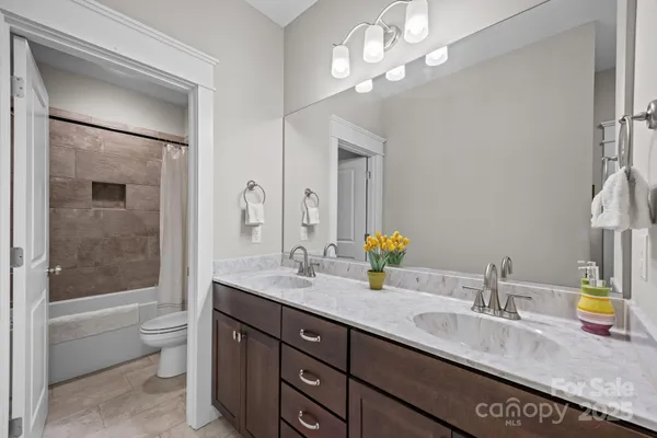 a bathroom with a granite countertop sink a toilet and a large mirror